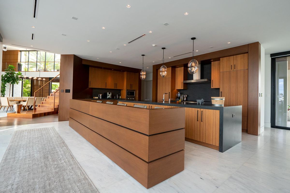 Sleek open kitchen with wooden cabinetry and black countertops