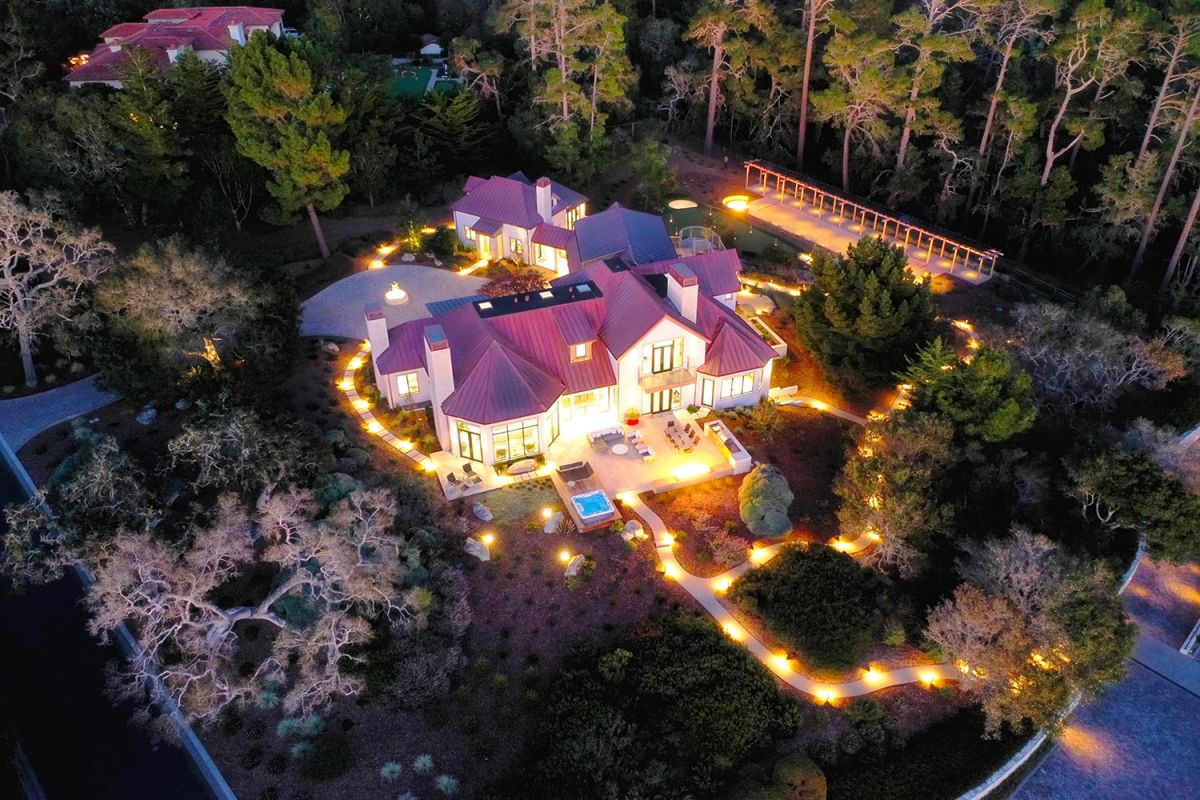 Evening aerial view of a modern estate lit with pathway lights