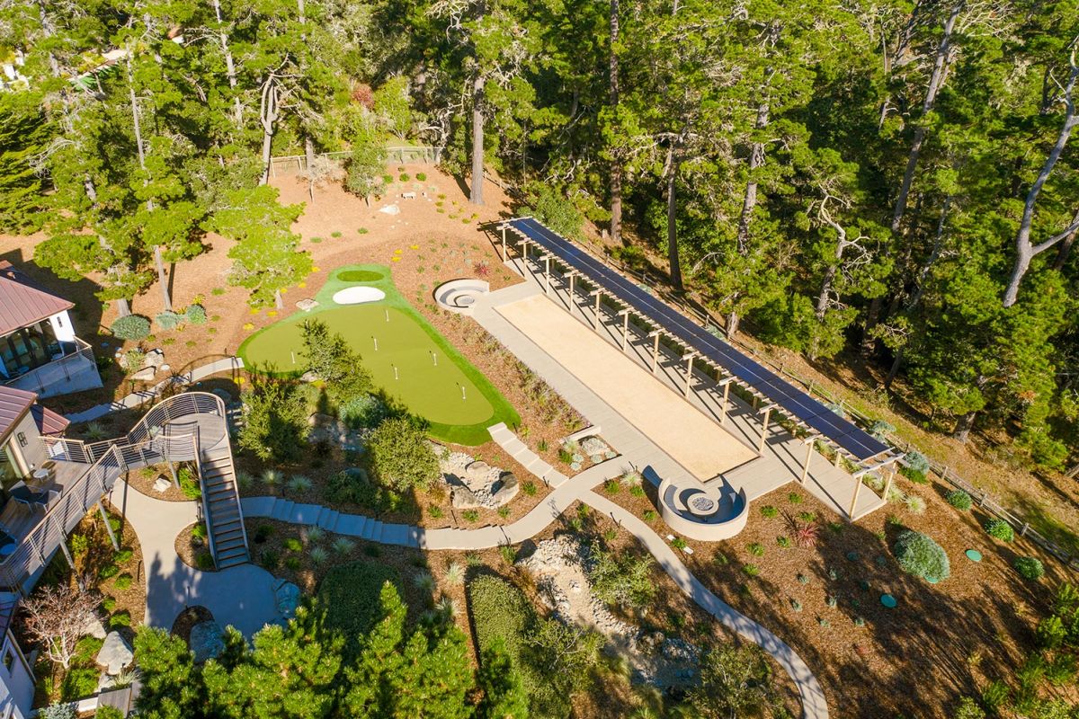 Aerial view of a landscaped backyard with putting green and bocce court