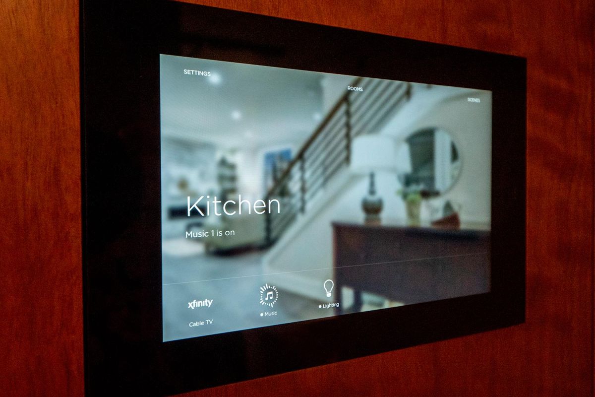 Wall-mounted smart home screen showing kitchen music and lighting settings