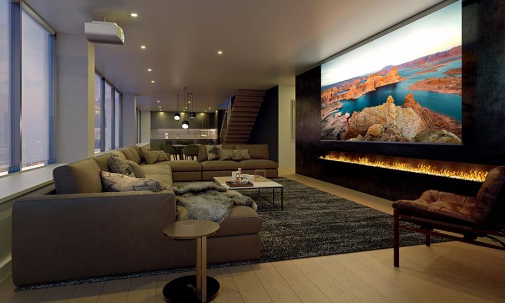 Home theater with a massive projector screen and cozy seating arrangement.