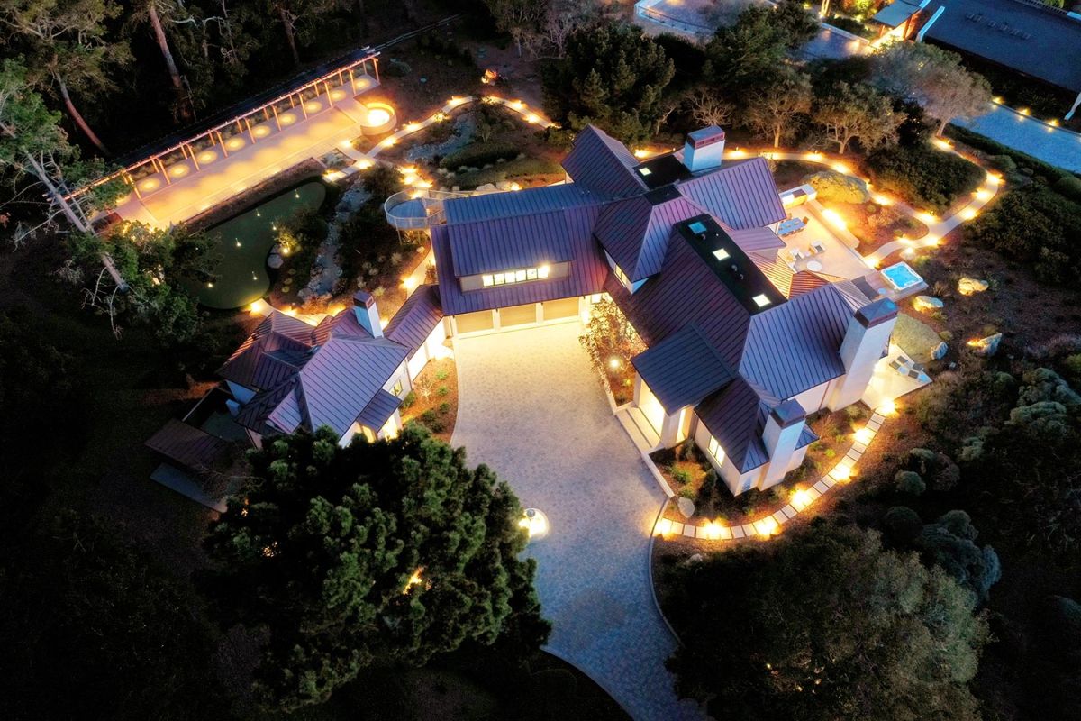 House and bocce court lit at night with overhead landscaping lights