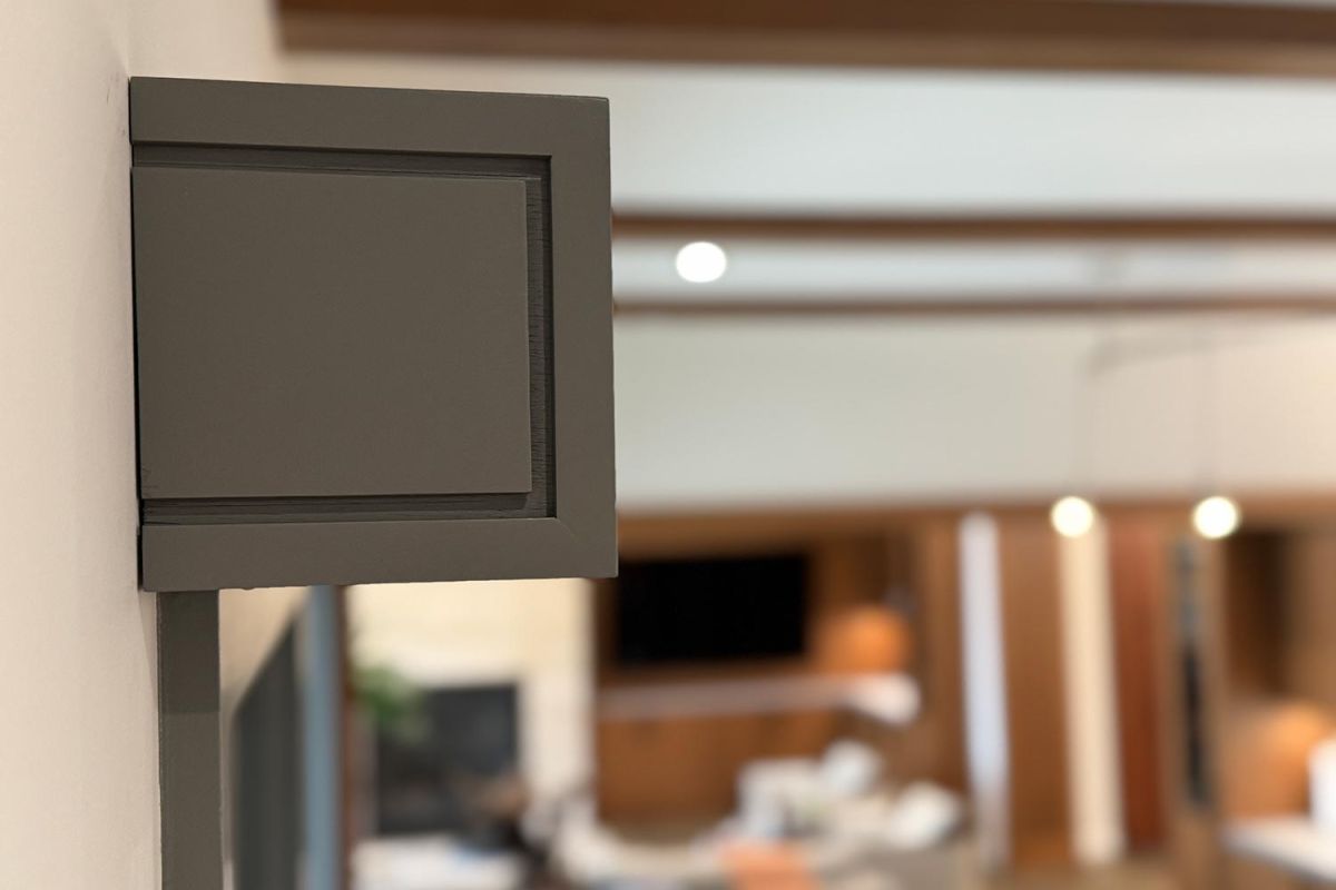 Close-up of a wall-mounted speaker facing a modern living room