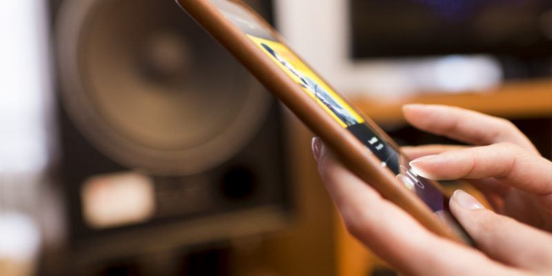 Woman listening music from a tablet Device connected