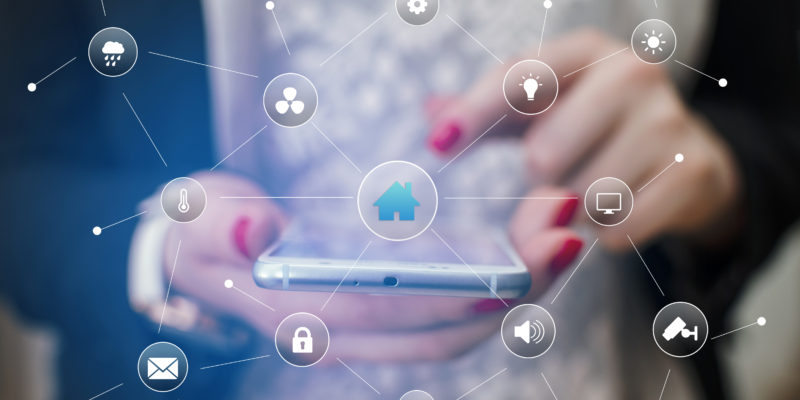 Girl hand holding phone surrounded with home remote control icons