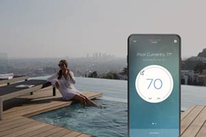 picture of the temperature control on the phone with view of the pool and a woman dipping her leg in the pool