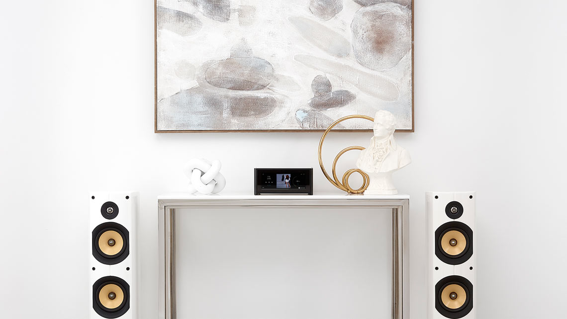 white wall with white table with speakers and stereo