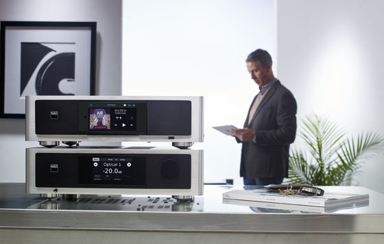 speaker on top of digital speakers with man in the background reading a paper