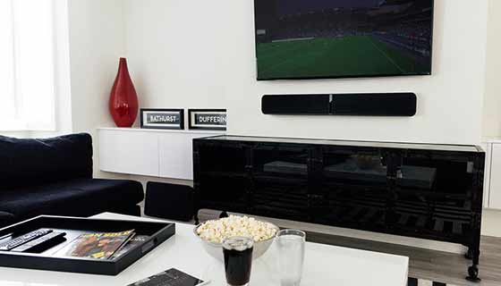 speakers under the tv living room view with popcorn on the table and glass of water